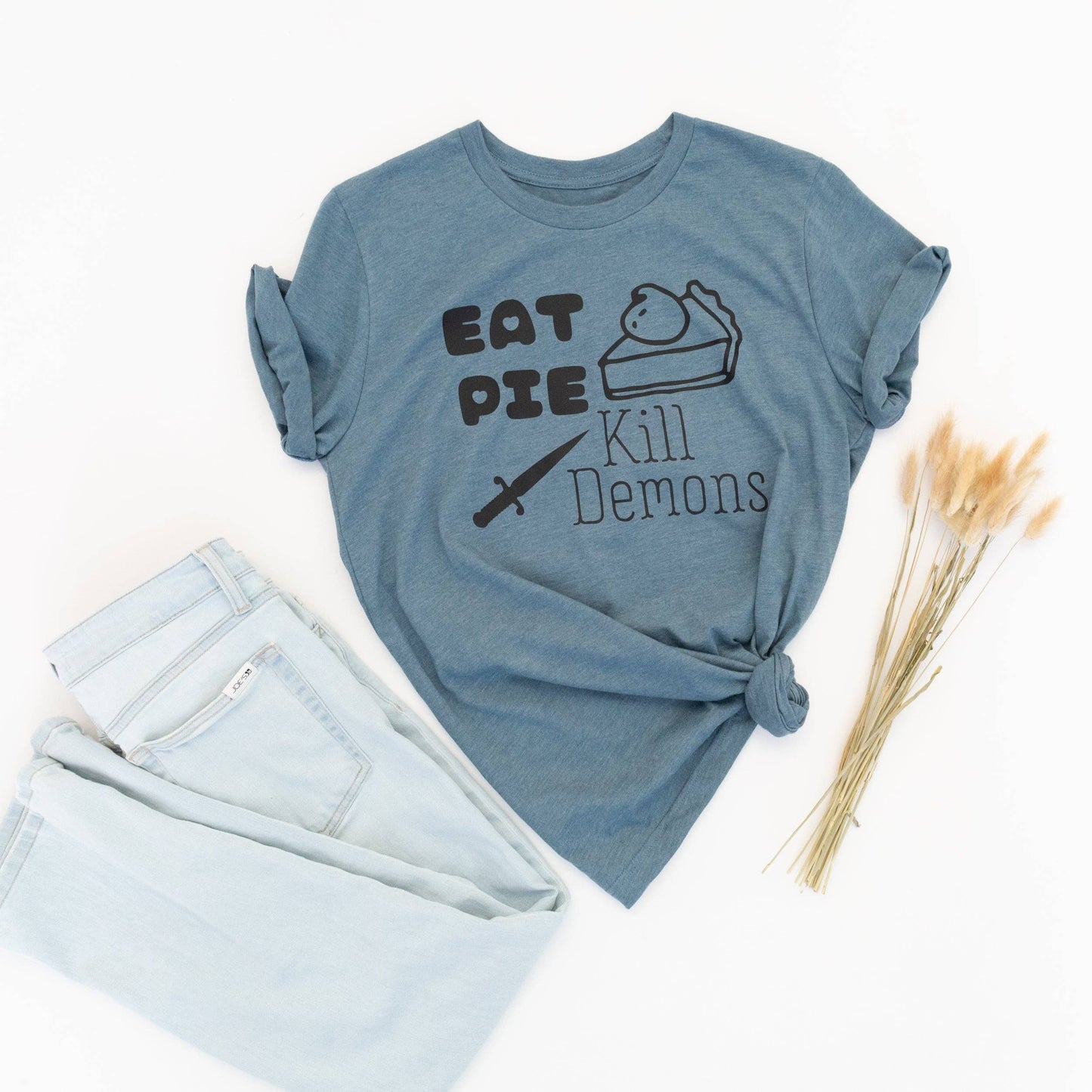 Blue t-shirt with text 'Eat Pie Kill Demons' on a white background