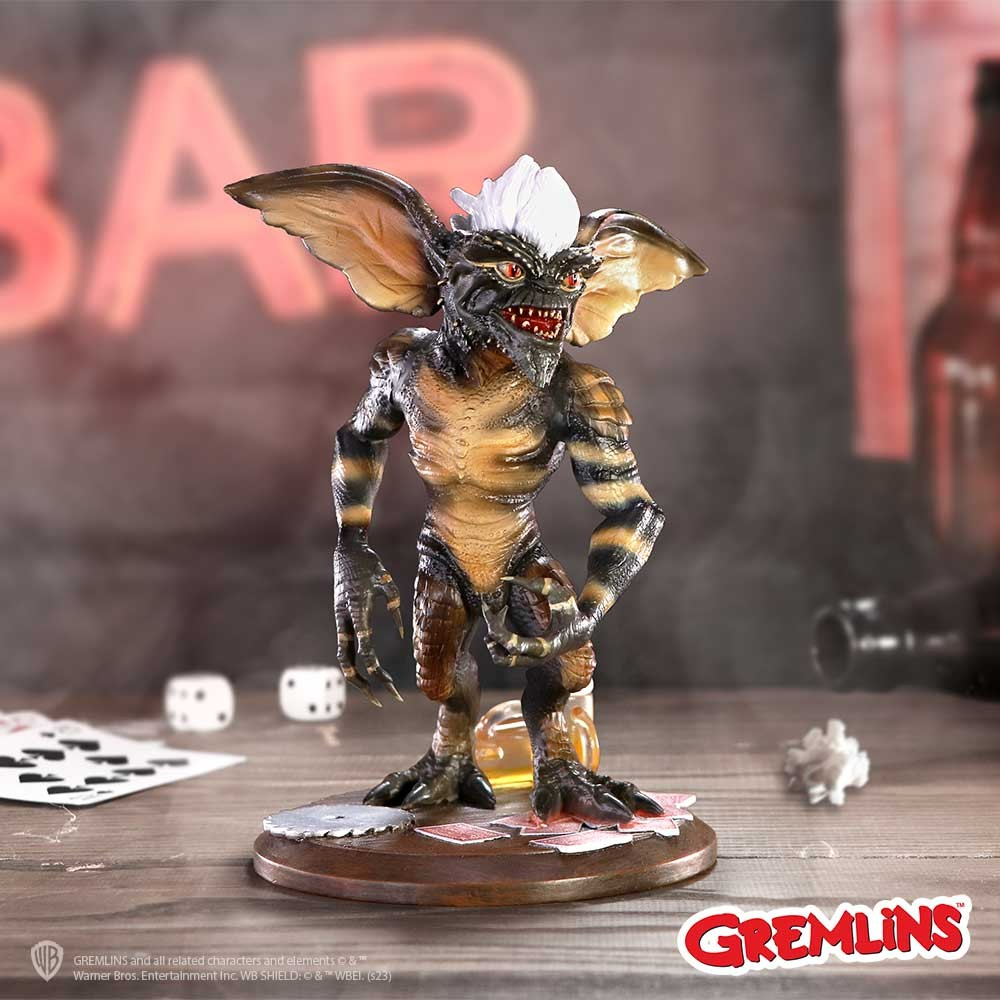 Gremlin figurine from Gremlins movie on a table with dice and cards, with 'GREMLINS' branding.