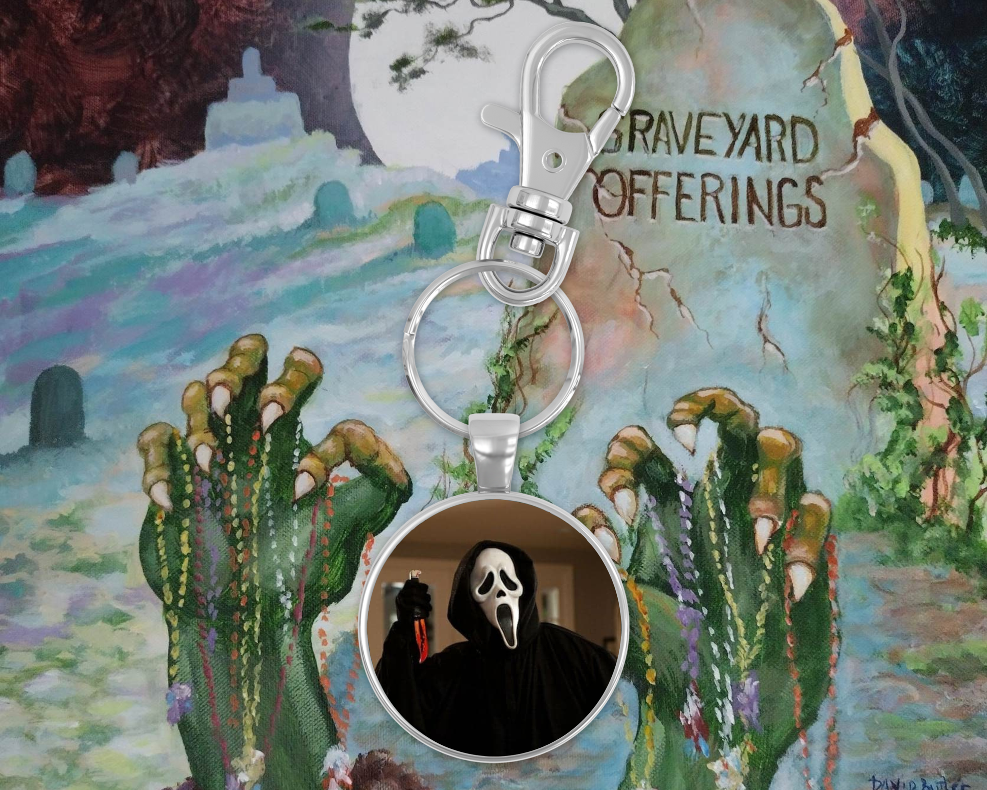 Keychain with Ghostface design on a colorful background resembling 'Graveyard Offerings' album cover.
