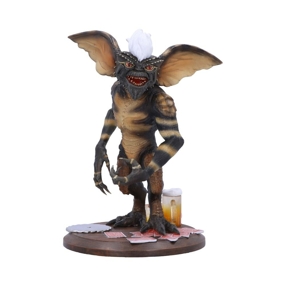 Gremlins figurine with a beer and playing cards on a white background