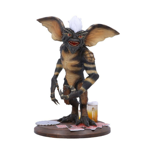 Gremlins figurine with a beer and playing cards on a white background