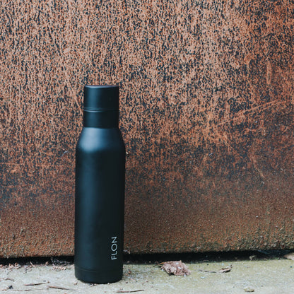 Black water bottle with 'ELON' branding against a textured brown background