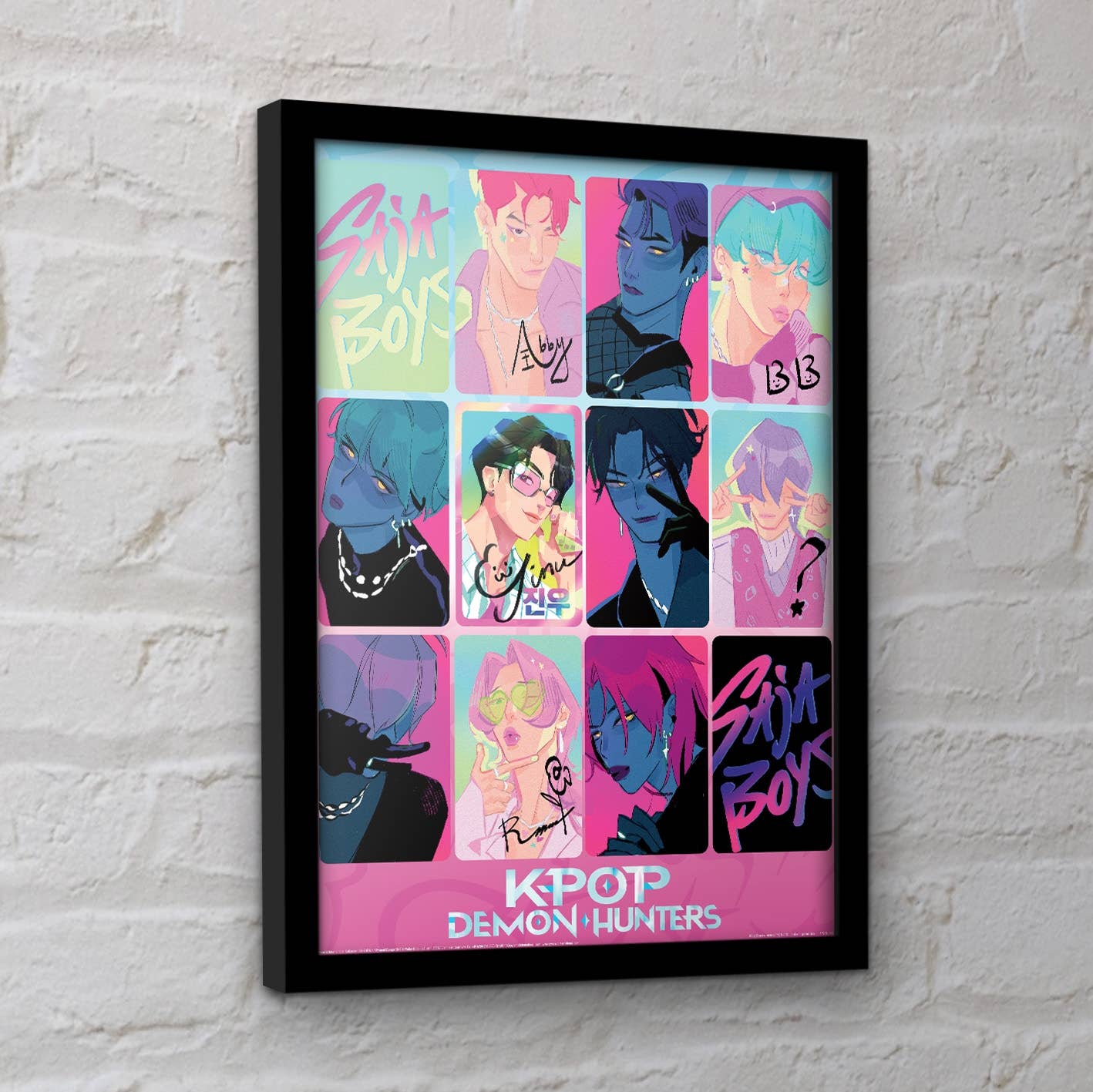 Framed poster with colorful KPOP Demon Hunters design on a white brick wall.
