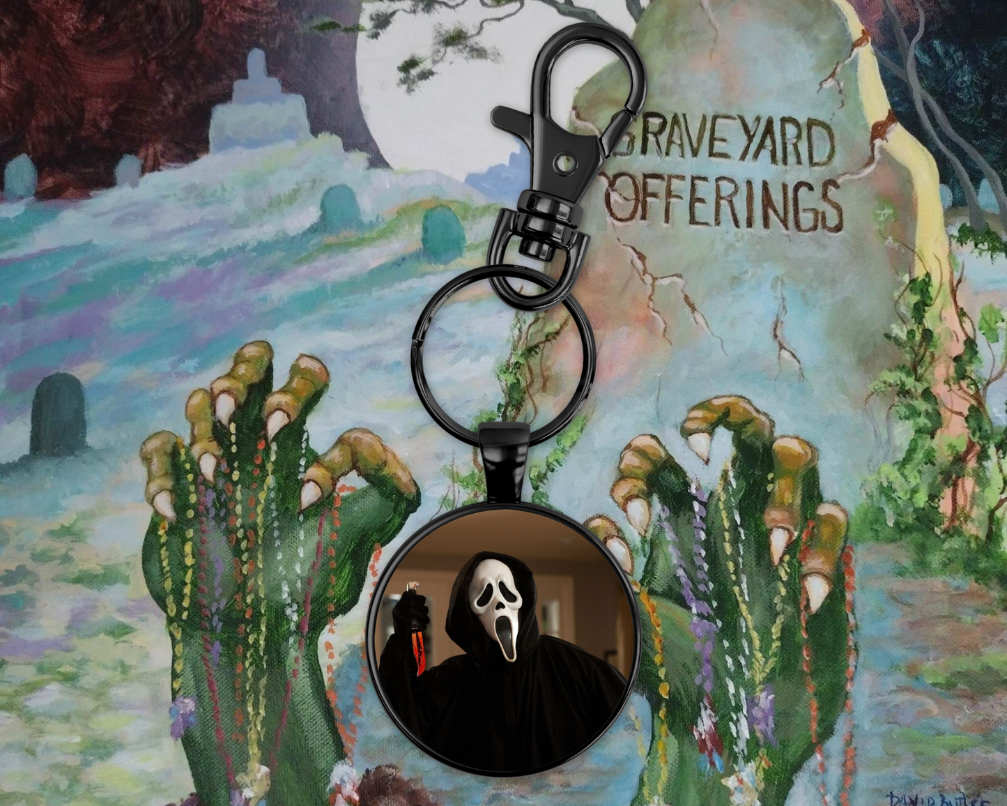Keychain with ghost face design on a colorful background with cacti and text.