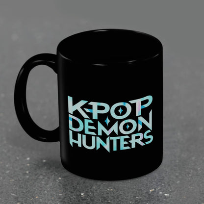 Black mug with 'K-Pop Demon Hunters' text in light blue on a gray background